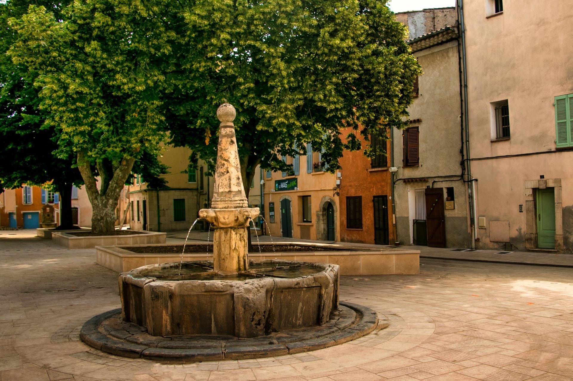 Dorfplatz von Ins mit Brunnen in ruhiger Morgenstimmung