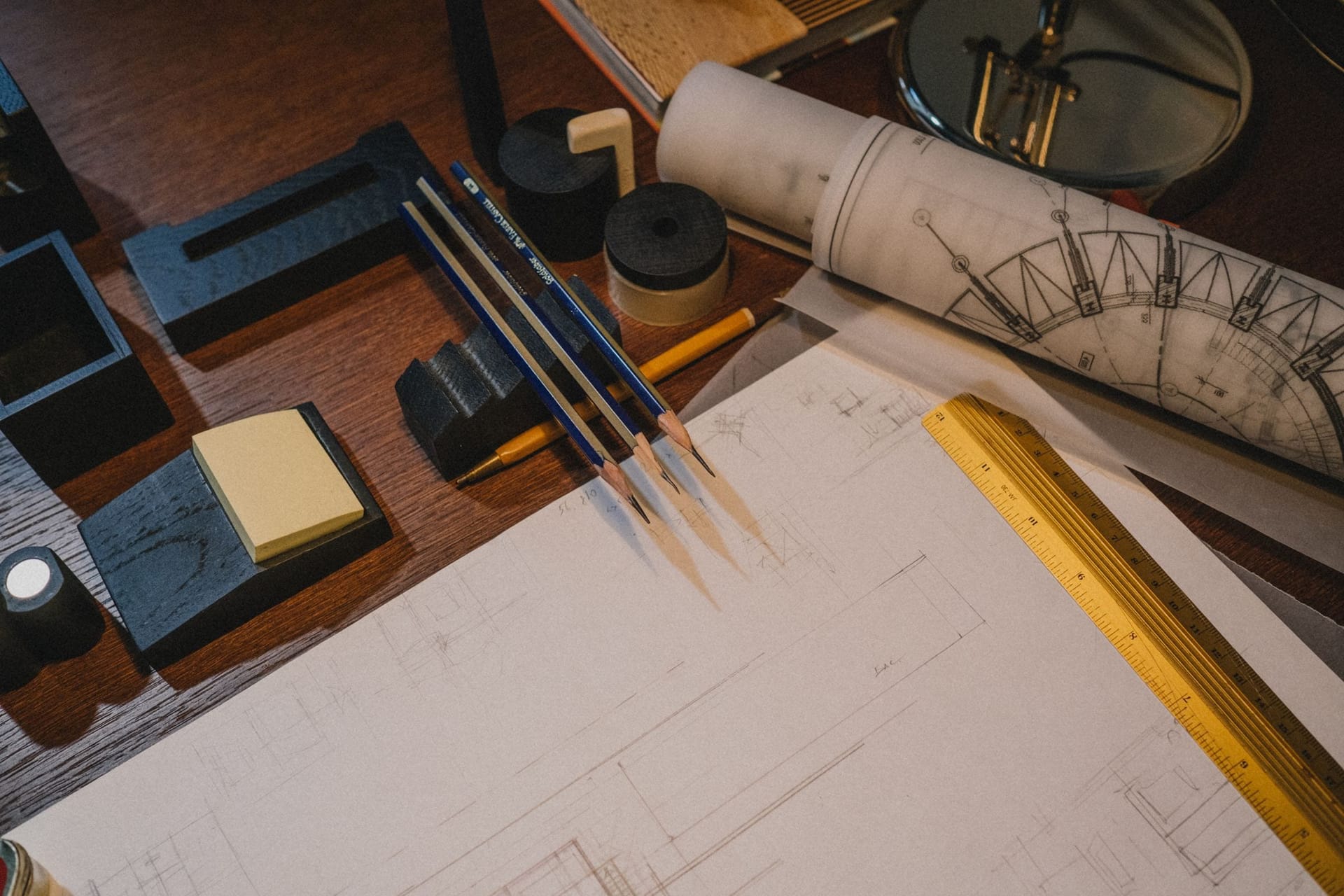 Architekturpläne und ein Arbeitsmodell auf einem Holztisch